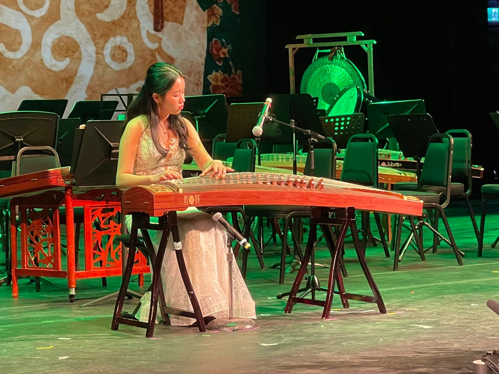 A guzheng musician performing on stage at a YCMA event
